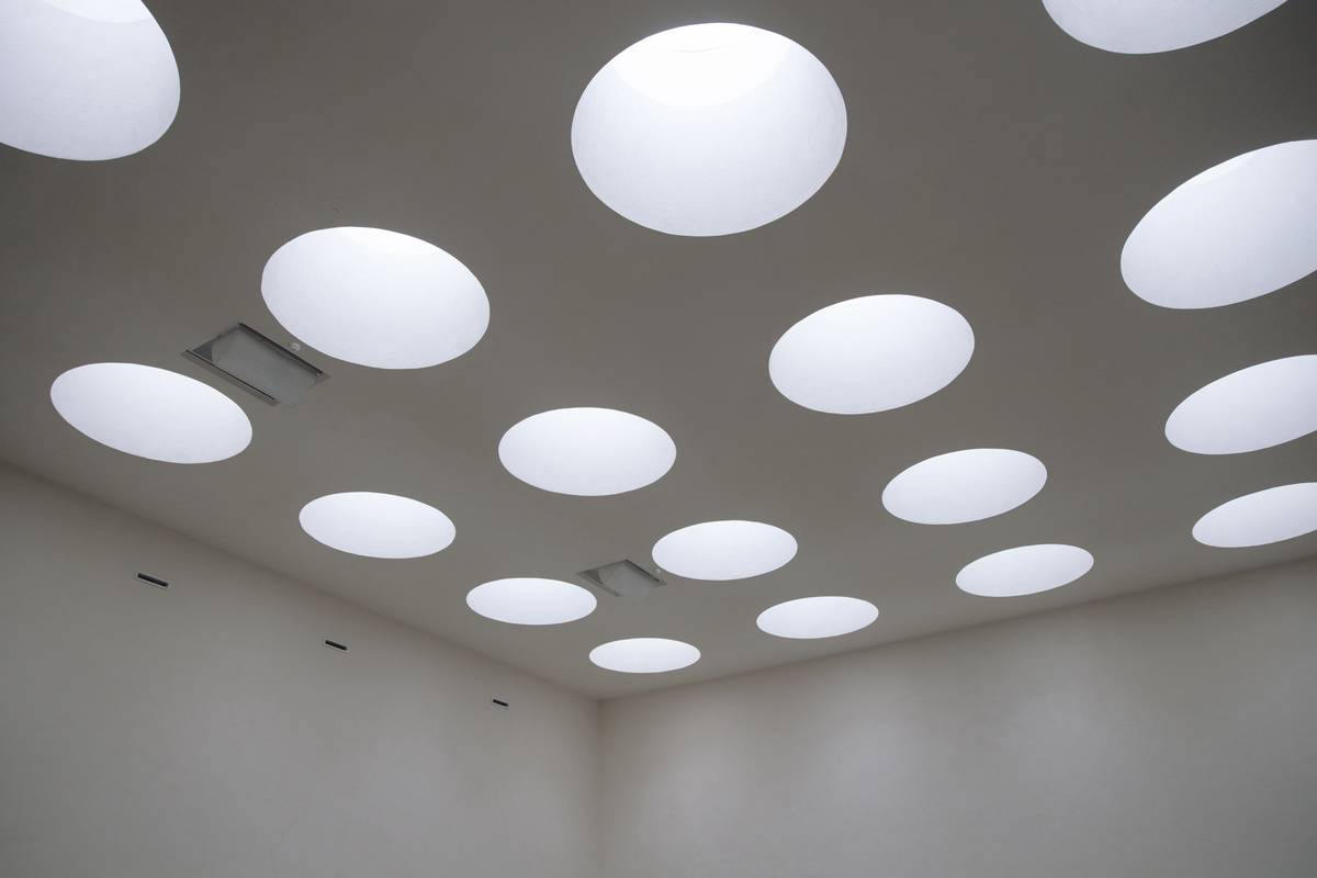 Comparison of recessed light fixtures for drop ceilings installed in a basement with labeled parts showing grid attachment