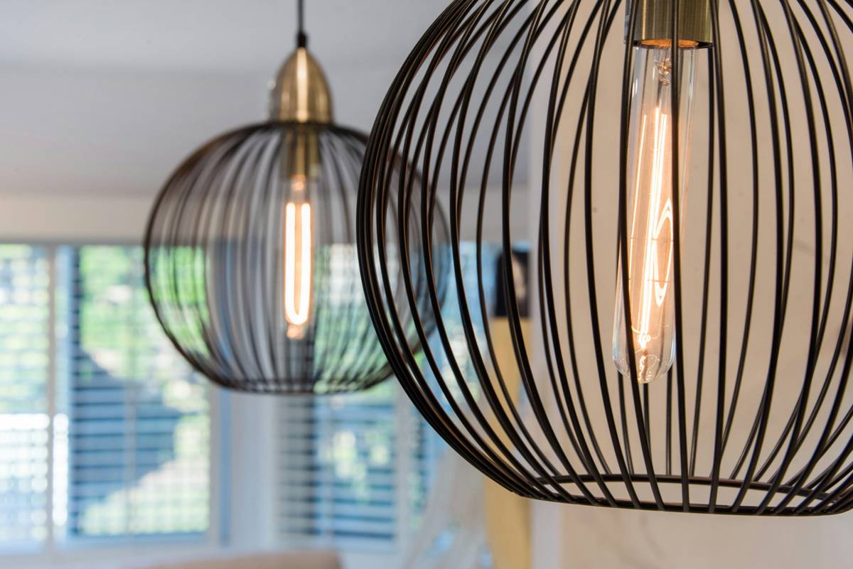 Professional recessed lighting fixtures installation showing evenly spaced LED cans in a modern living room ceiling